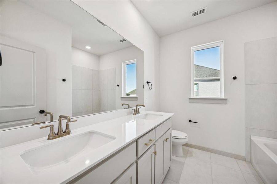 With dual sinks, guests will have their own vanity space in this lovely guest bath. With dual sinks, guests will have their own vanity space in this lovely guest bath.