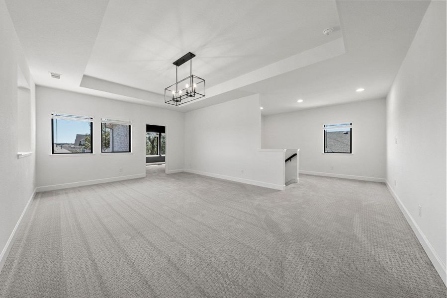 Unfurnished room featuring baseboards, visible vents, light colored carpet, a tray ceiling, and recessed lighting