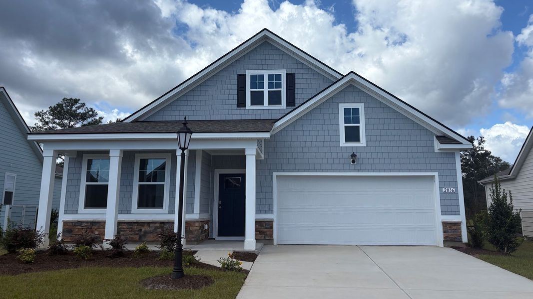 Front exterior of a new home in Rich Square at Brunswick Plantation, Ash, NC, highlighting curb appeal (Image 1).