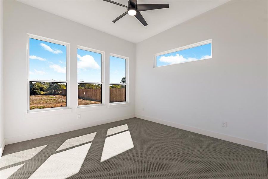 Spacious room with high ceilings, featuring three vertical windows and one horizontal transom window Spacious room with high ceilings, featuring three vertical windows and one horizontal transom window