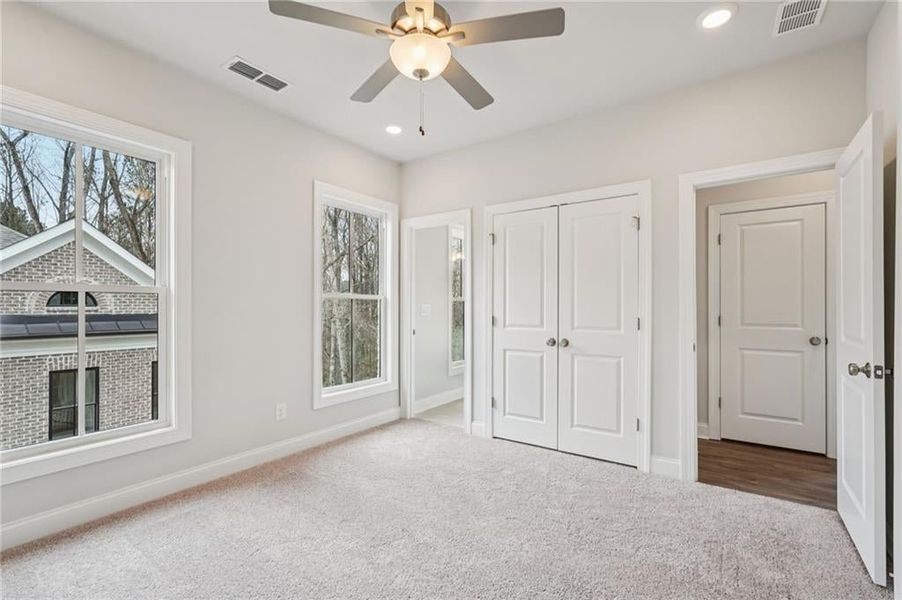 Unfurnished bedroom with carpet, a ceiling fan, a closet, and recessed lighting