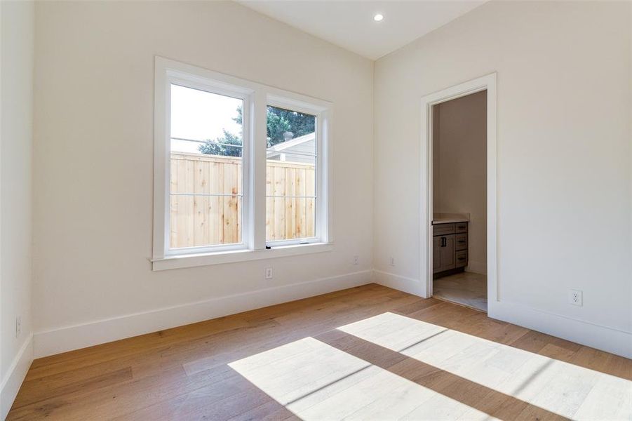 Unfurnished bedroom featuring light wood-type flooring and ensuite bathroom