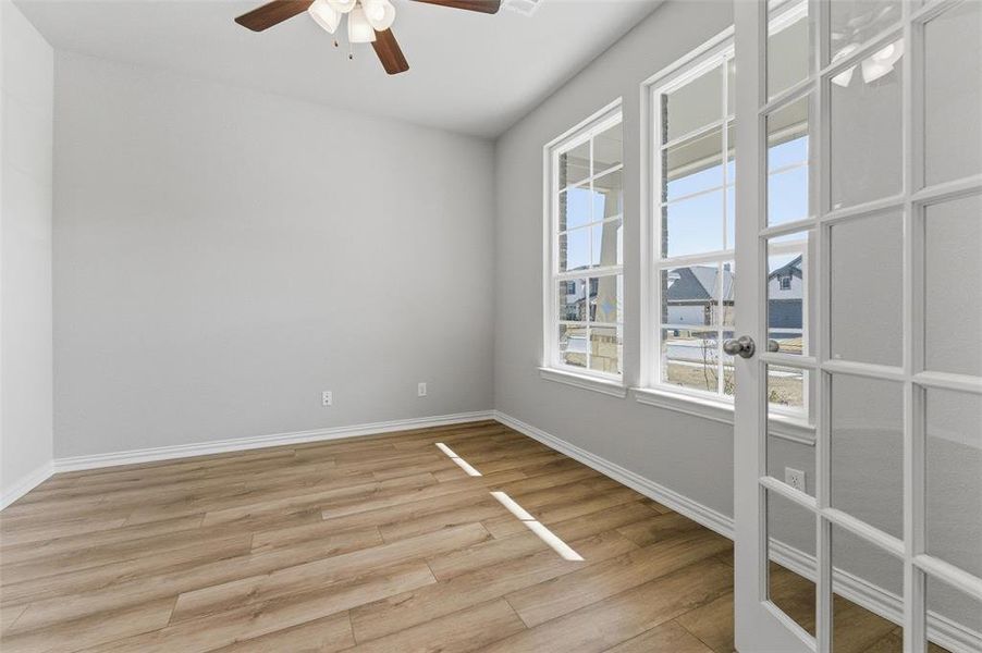 Empty room featuring ceiling fan and light wood-style floors