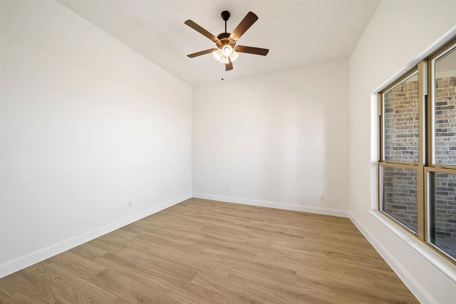 Unfurnished room with light wood finished floors and ceiling fan