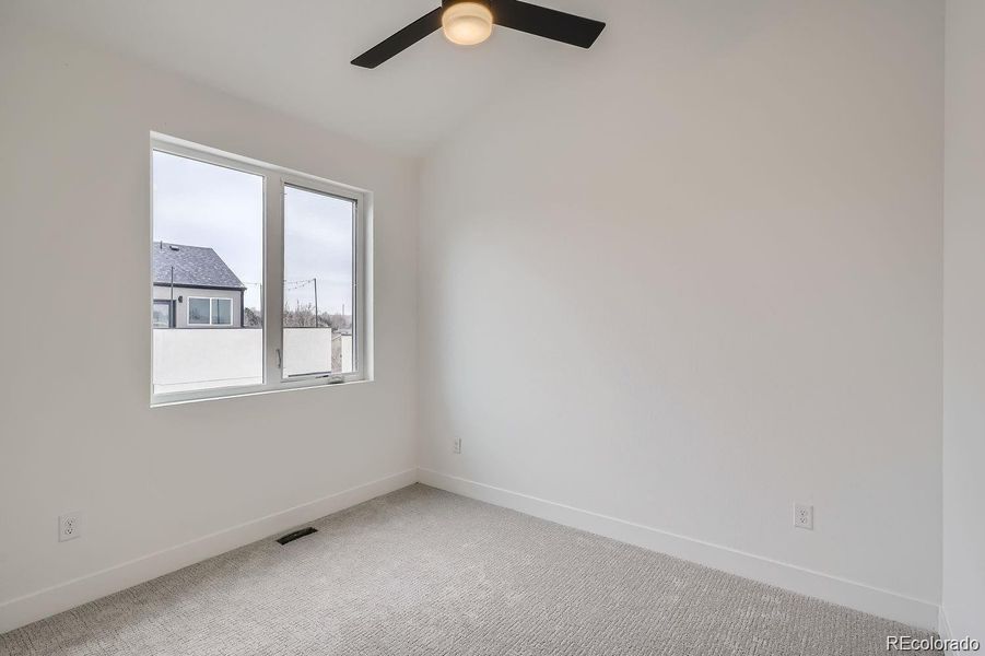 One of two extra bedrooms on 3rd level with vaulted ceilings, large closets, and ceiling fans. Great options for guest rooms or additional office space.