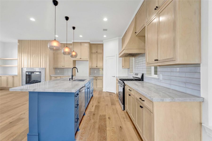 The kitchen features custom-built cabinets, Taj Mahal countertops, ample storage, and a walk-in pantry.