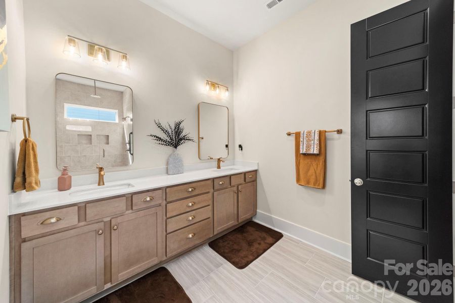 Spa Like Primary Bathroom with Dual Vanities, 4 Drawer Stack Cabinets and Gold Metal Framed Mirrors
