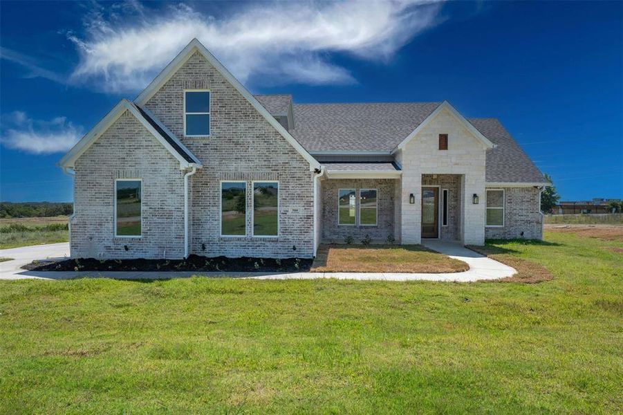 View of front of house featuring brick siding, roof with shingles, and a front yard View of front of house featuring brick siding, roof with shingles, and a front yard