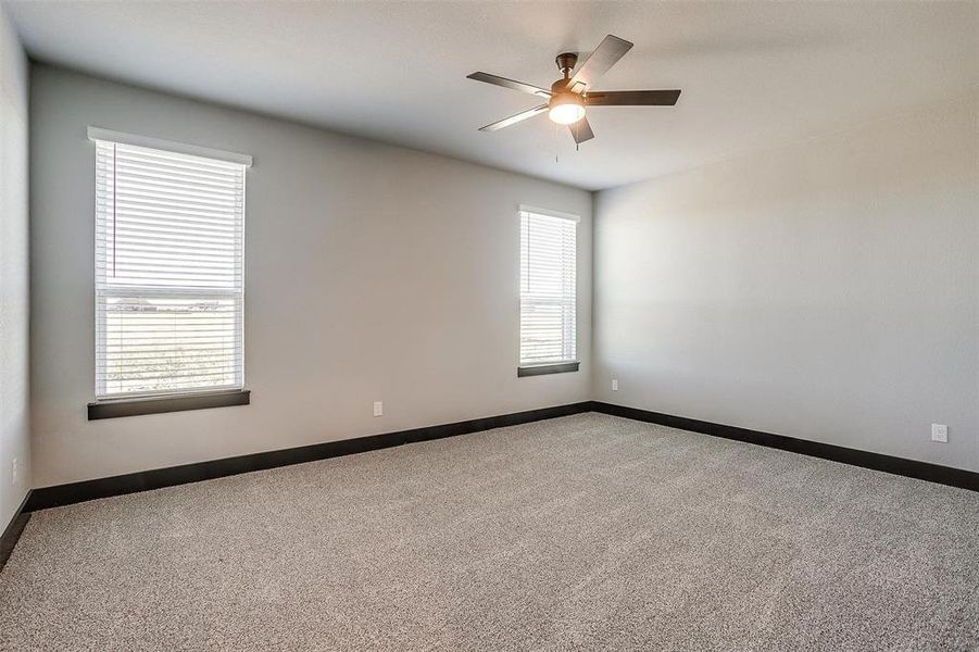 Carpeted empty room with ceiling fan