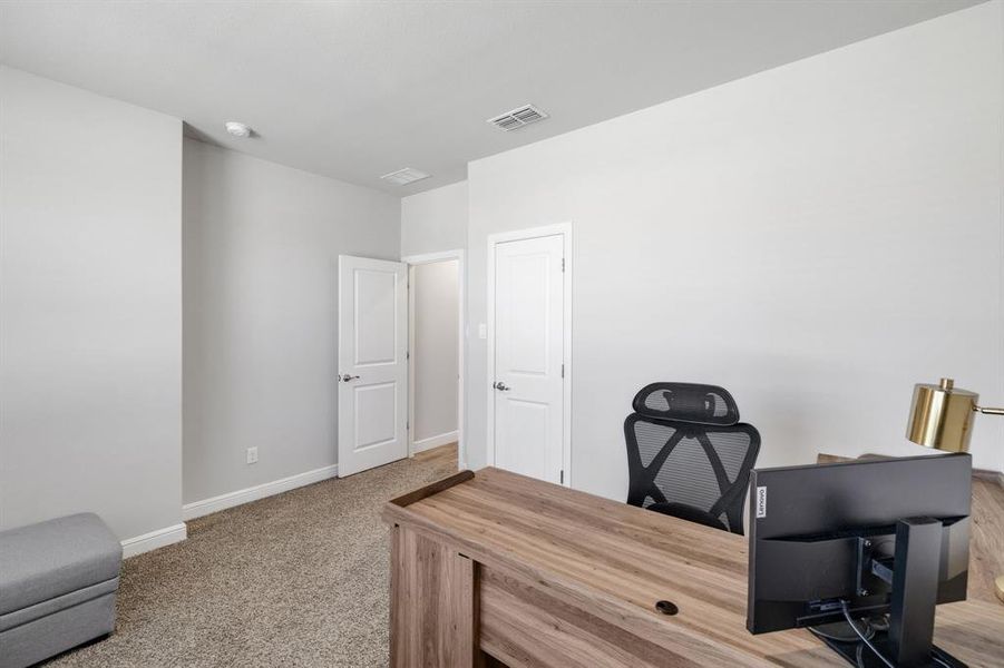 Carpeted office space with baseboards