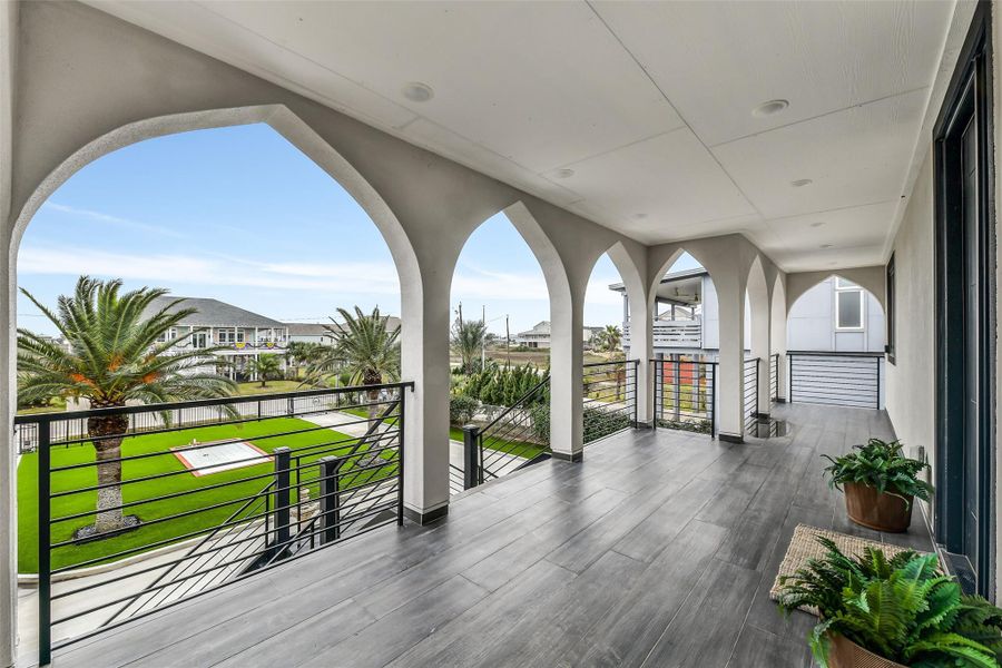 Architectural arches bring timeless character to the front elevation. Multiple covered terraces offer breezy places to welcome guests or enjoy a quiet morning above the landscaped grounds. Architectural arches bring timeless character to the front elevation. Multiple covered terraces offer breezy places to welcome guests or enjoy a quiet morning above the landscaped grounds.