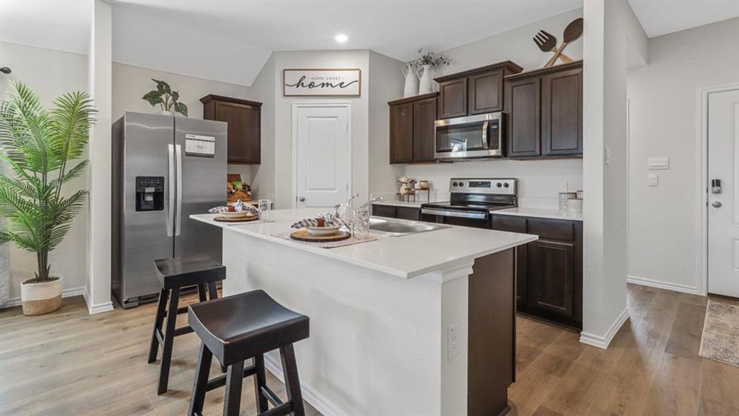 Kitchen featuring an island with a white countertop and integrated sink