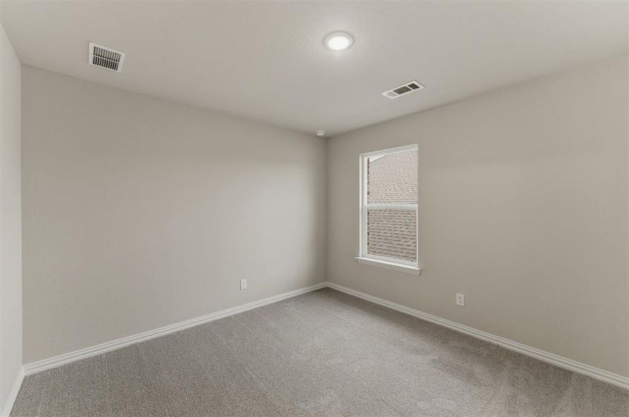 Neutral-toned room featuring a single window, recessed lighting, and light gray carpeting
