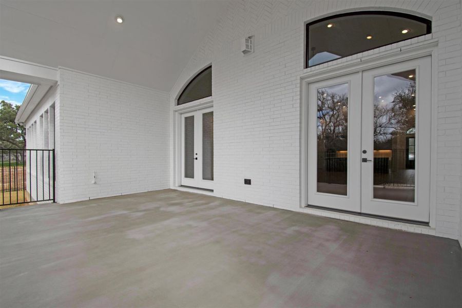 Extended Covered Backyard Patio with double french doors, an outdoor living space with scenic greenbelt views