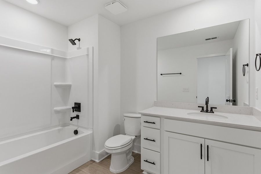 A bathroom with a tub toilet and sink.