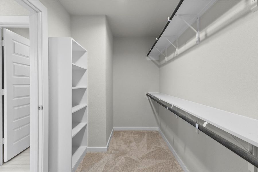 Generous walk-in closet offers built-in shelving and multiple hanging areas for organized storage. Generous walk-in closet offers built-in shelving and multiple hanging areas for organized storage.