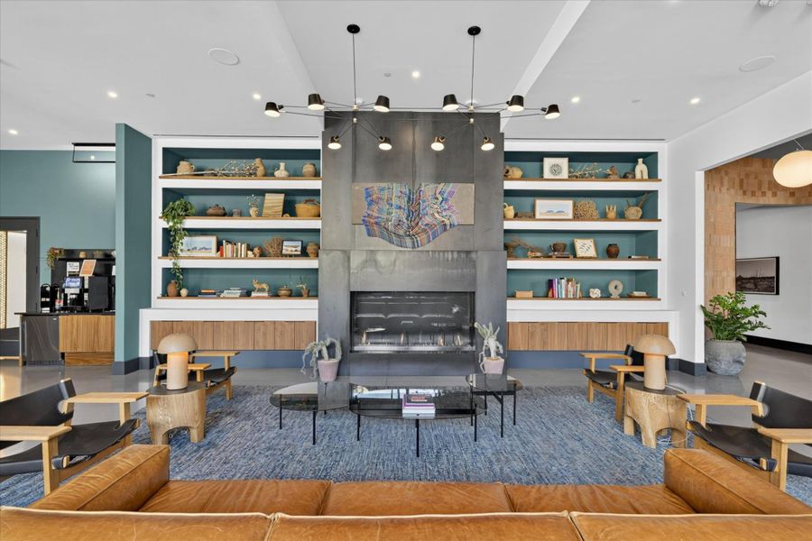 A welcoming living room featuring a grand fireplace with built-in shelving, complemented by rich blue carpeting and modern lighting.