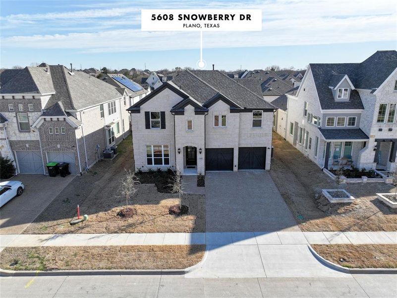 View of front facade featuring a garage, driveway, and a residential view