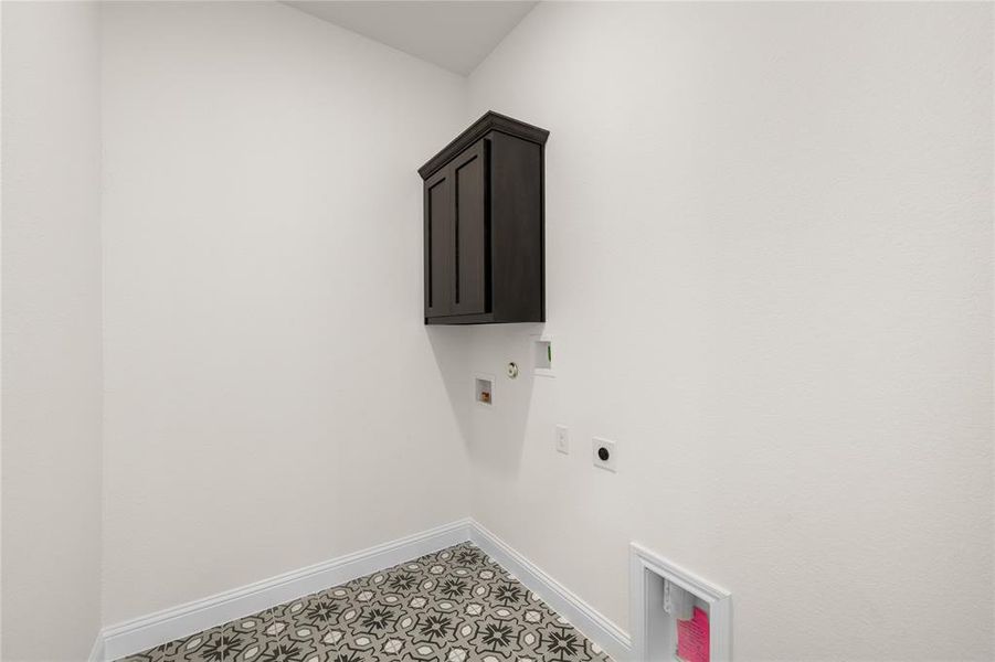 Washroom featuring electric dryer hookup, cabinet space, hookup for a washing machine, light flooring, and hookup for a gas dryer