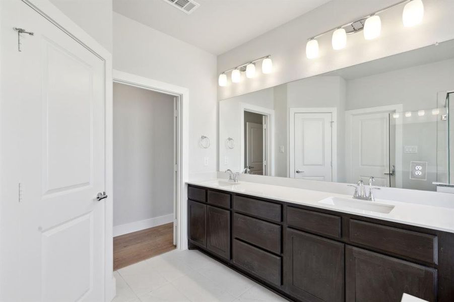 Bathroom featuring tile patterned floors and double sink vanity