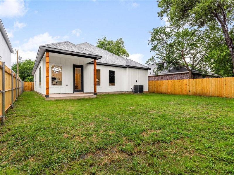Back of house with roof with shingles, a patio, a fenced backyard, and board and batten siding