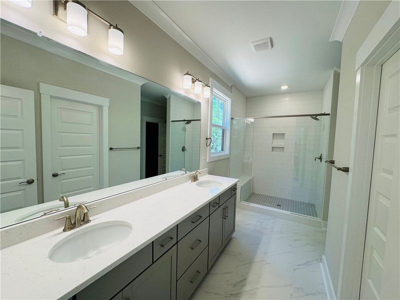 This spacious bathroom offers a double vanity and