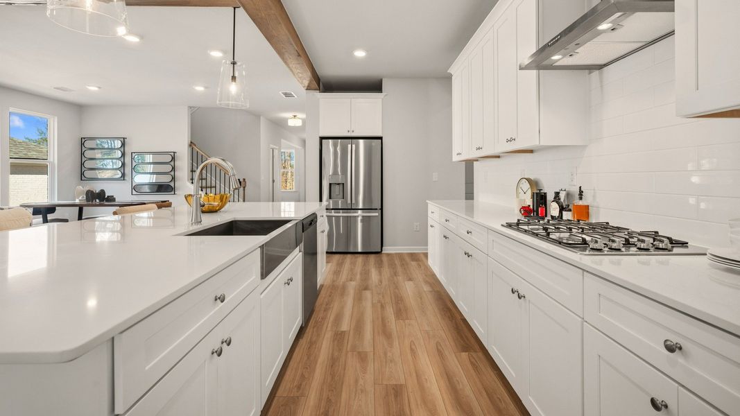 Kitchen with tile backsplash, quartz countertops, and pendant lighting Kitchen with tile backsplash, quartz countertops, and pendant lighting