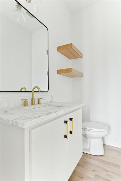 Bathroom with wood-type flooring, vanity, and toilet