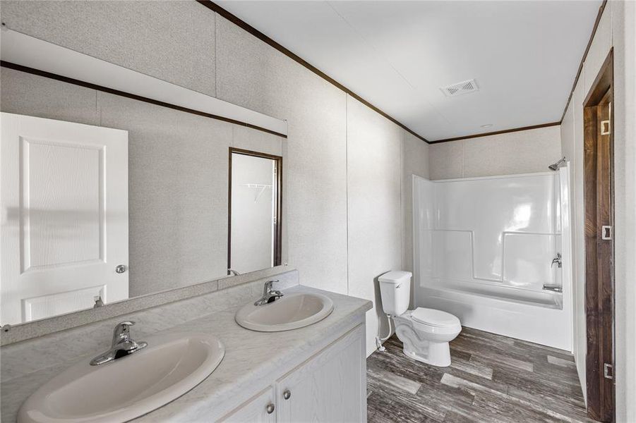 Full bathroom featuring toilet, hardwood / wood-style floors, shower / bathtub combination, and vanity