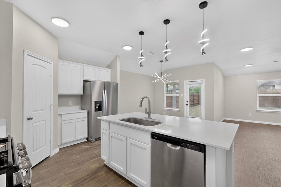 Gleaming stone counters and warm wood floors define this airy open kitchen and living area.