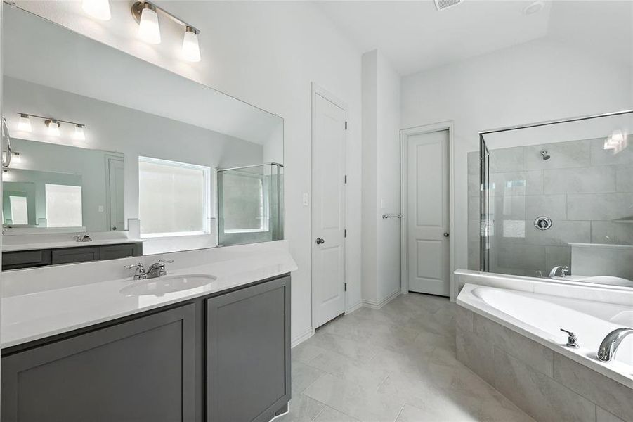 Bathroom with a garden tub, vanity, and a tile shower Bathroom with a garden tub, vanity, and a tile shower