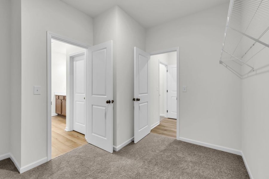 Walk in closet with access to the laundry room (Right) and to the primary bathroom (left). Walk in closet with access to the laundry room (Right) and to the primary bathroom (left).