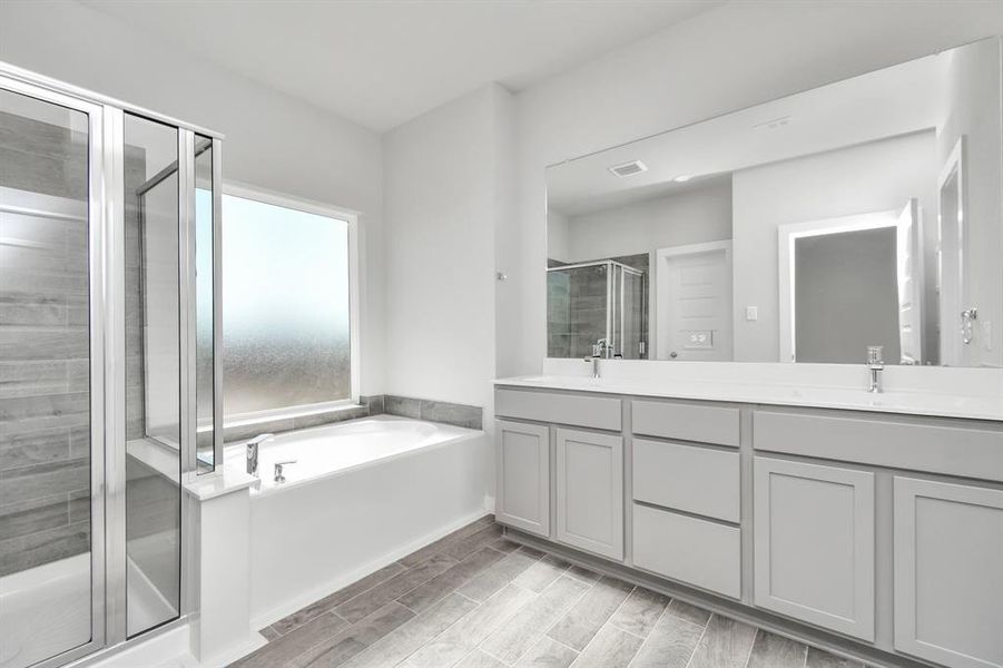 Indulge in a spa-like retreat within the confines of this primary bathroom. Sample photo of completed home with similar floor plan. As-built interior colors and selections may vary.