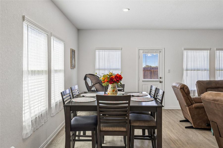 Dining area featuring wood-finish flooring, recessed lighting, and multiple windows with blinds Dining area featuring wood-finish flooring, recessed lighting, and multiple windows with blinds