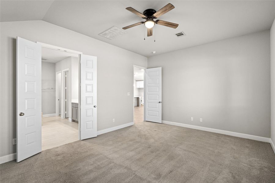 Primary Bedroom angle showing the hallway access to the private spa-like bath and Two Separate Walk-in Closets.