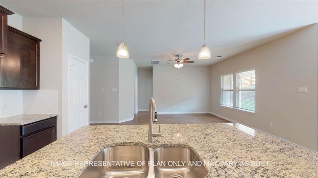 Kitchen featuring dark brown cabinets, a sink, decorative light fixtures, ceiling fan, and light stone countertops Kitchen featuring dark brown cabinets, a sink, decorative light fixtures, ceiling fan, and light stone countertops