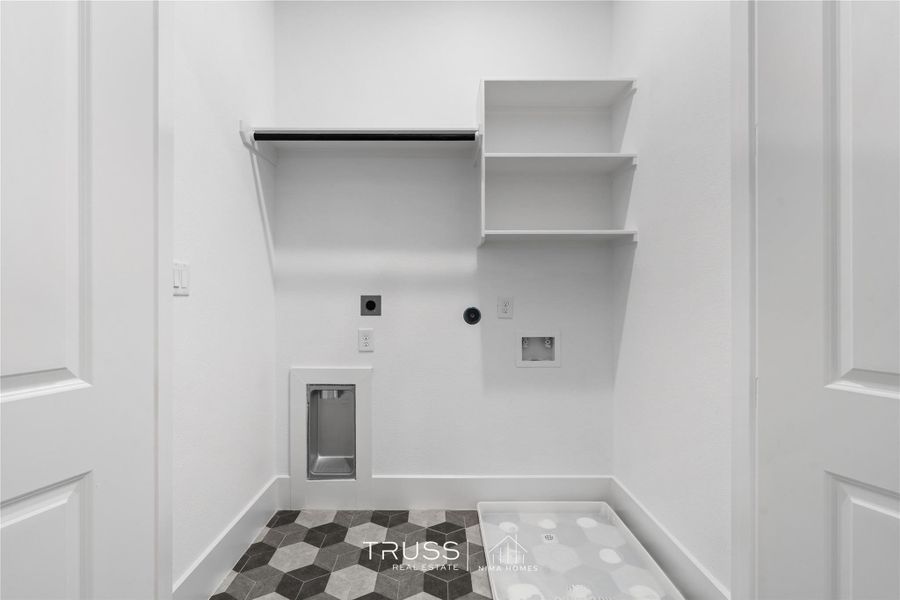 The dedicated laundry room pairs practicality with polish. Complete with built-in shelving and easy access flow.