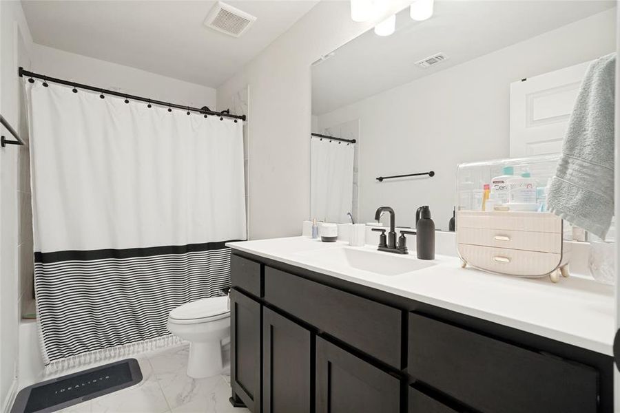 Bathroom featuring a dark wood-finish vanity with a white countertop and integrated sink