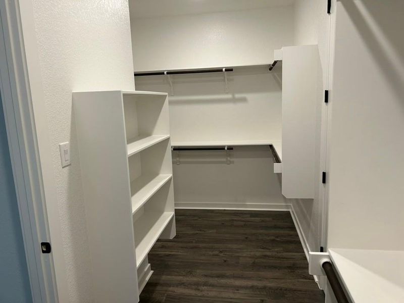 Walk in closet with dark wood-style floors Walk in closet with dark wood-style floors