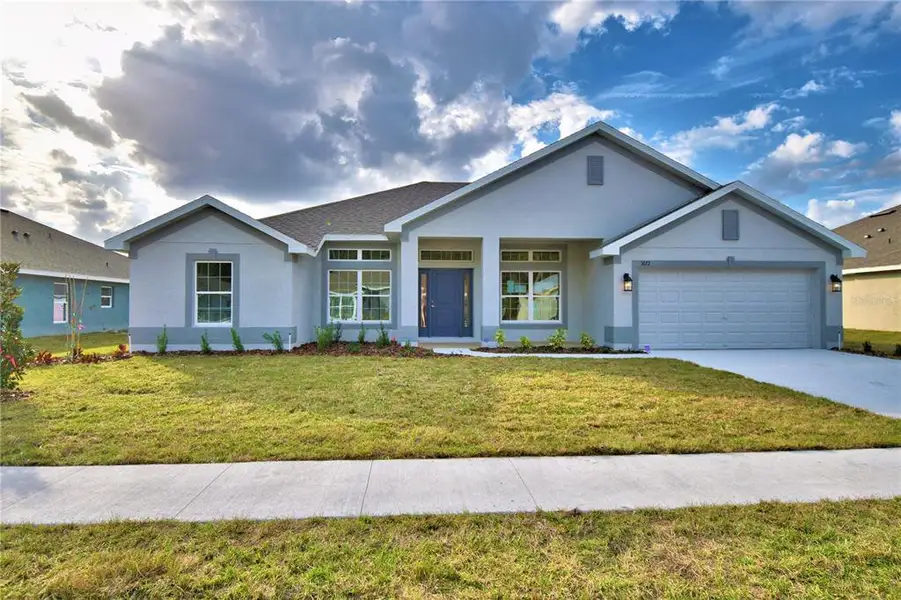 Front exterior of a new home in Cadence Crossing, Auburndale, FL, highlighting curb appeal (Image 1).
