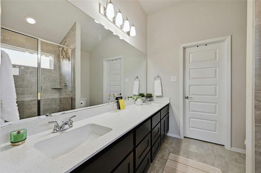 Quartz countertop, dual vanity, large walk-in shower, and large walk-in closet.