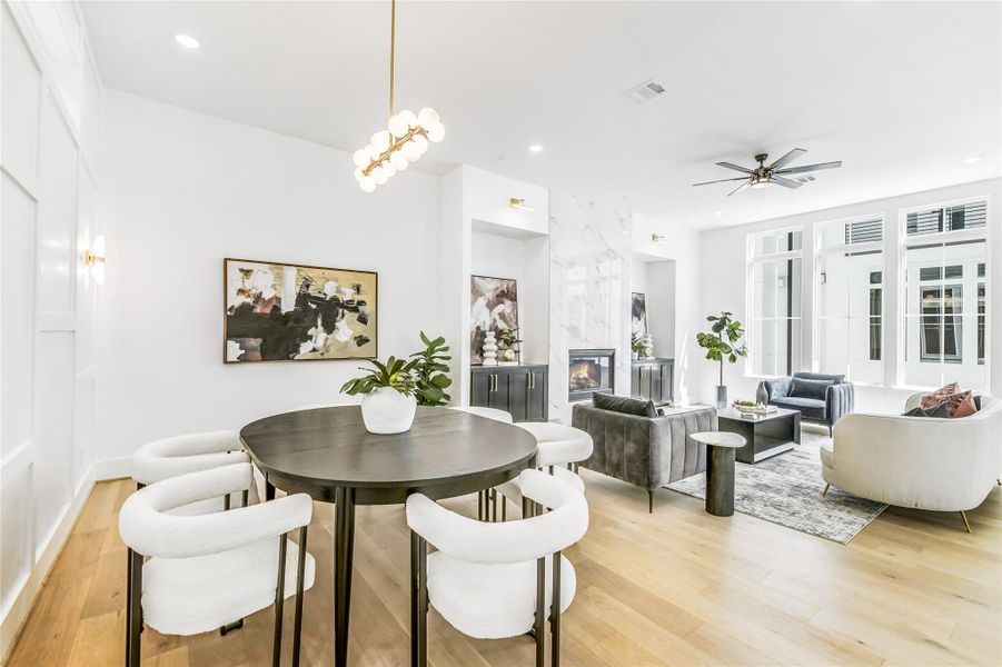 Perfectly positioned for open-concept living, the dining room flows seamlessly into the bright, airy family space anchored by a porcelain-wrapped fireplace. Every element—from the custom trimwork and recessed lighting to the brushed-brass fixtures—showcases meticulous builder attention to detail, ideal for professionals who appreciate refined design and easy hospitality.