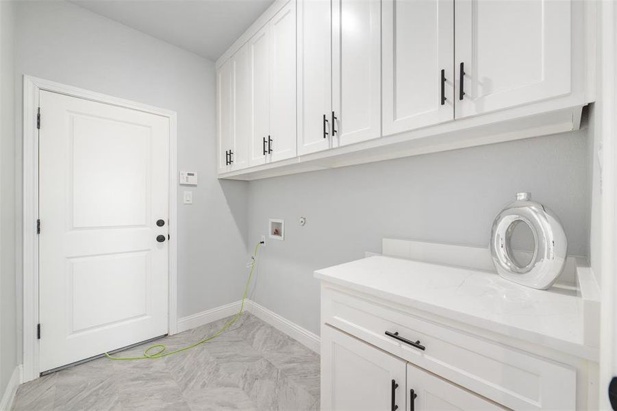 Laundry area with cabinets and hookup for a washing machine