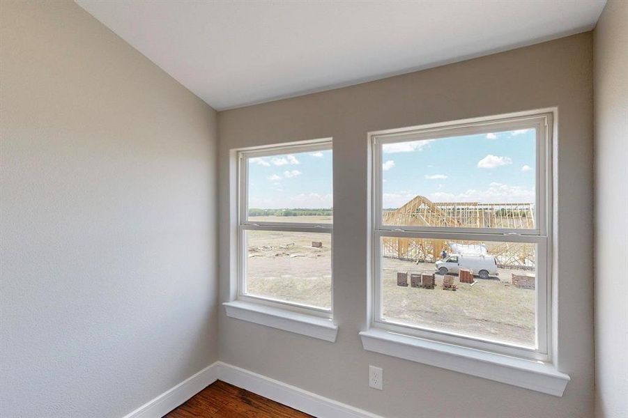 Unfurnished room with wood-type flooring and a healthy amount of sunlight