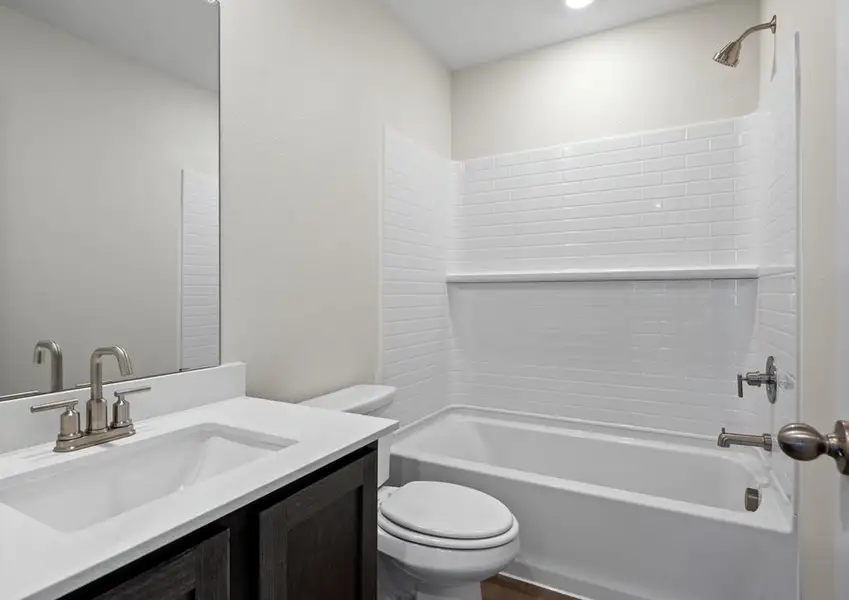 The secondary bathroom has a large vanity space and a shower-tub combo. The secondary bathroom has a large vanity space and a shower-tub combo.