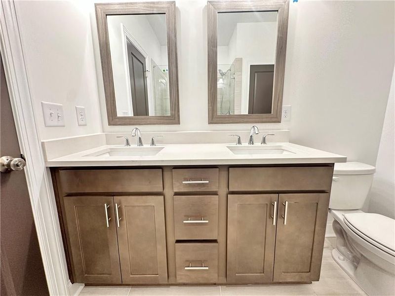 Dual vanity with quartz countertops and framed mirrors *Photos Showcase Warm Wheat Design Collection from a different Staged Model Home Site*