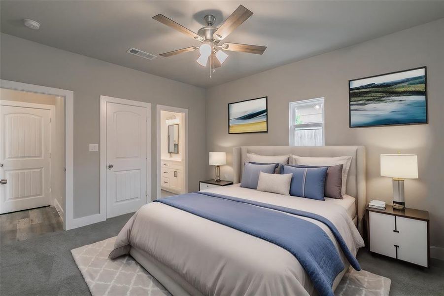 Primary Bedroom Carpeted bedroom featuring ceiling fan and ensuite bath