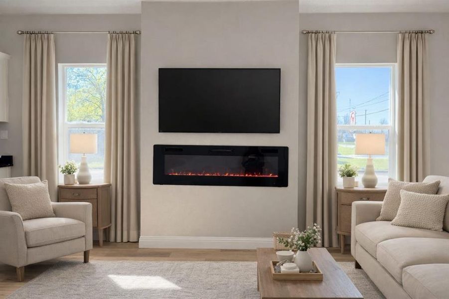 Living area featuring light wood-style floors and a glass covered fireplace