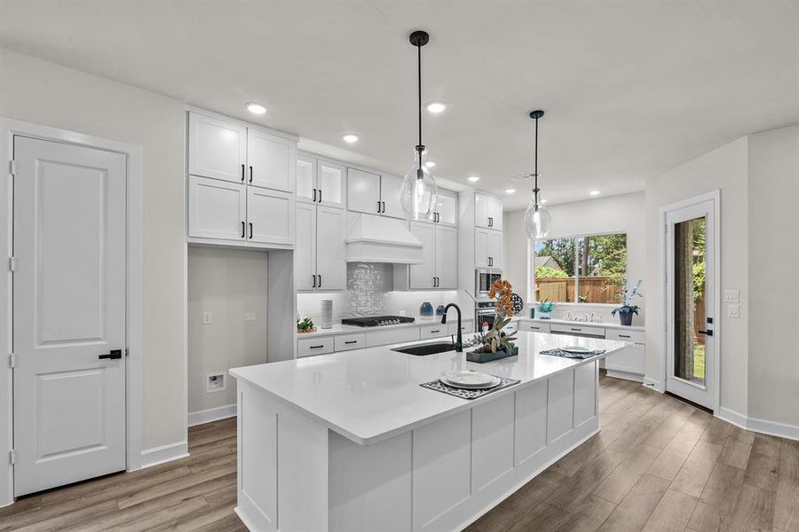 EXAMPLE PHOTO: Quartz counters, gas cooktop with updraft vent hood compliment this beautiful kitchen.  Cabinets to ceiling optional.