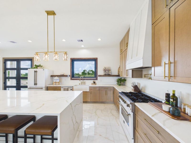 Spacious kitchen with oversized island, gas range, and ample cabinetry